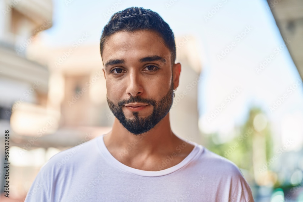 Young arab man standing with serious expression at street Young arab man standing with serious expression at street