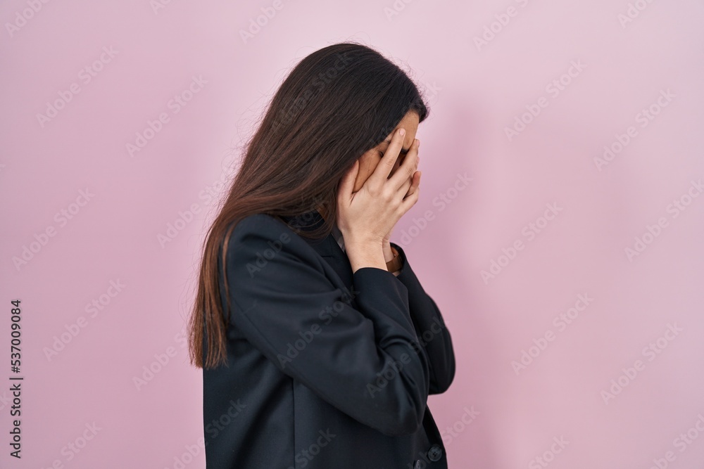 Young brunette woman wearing business style over pink background with sad expression covering face with hands while crying. depression concept. Young brunette woman wearing business style over pink background with sad expression covering face with hands while crying. depression concept.