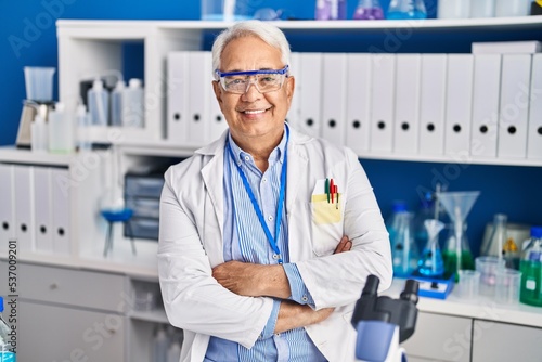 Senior man scientist smiling confident with arms crossed gesture at laboratory