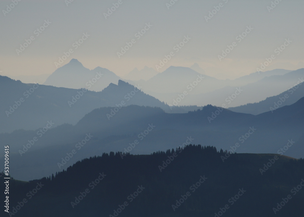 Naklejka premium Layered mountain ranges in different shades of blue.