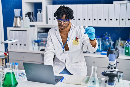 African american man scientist using laptop at laboratory
