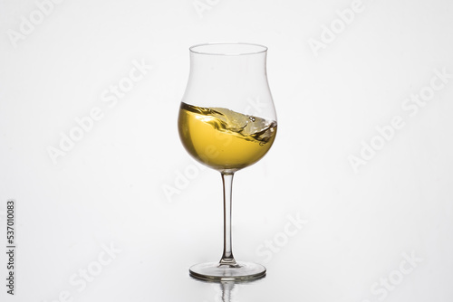 white wine on the move, in tulip glass, winemaking, wineries, white background.