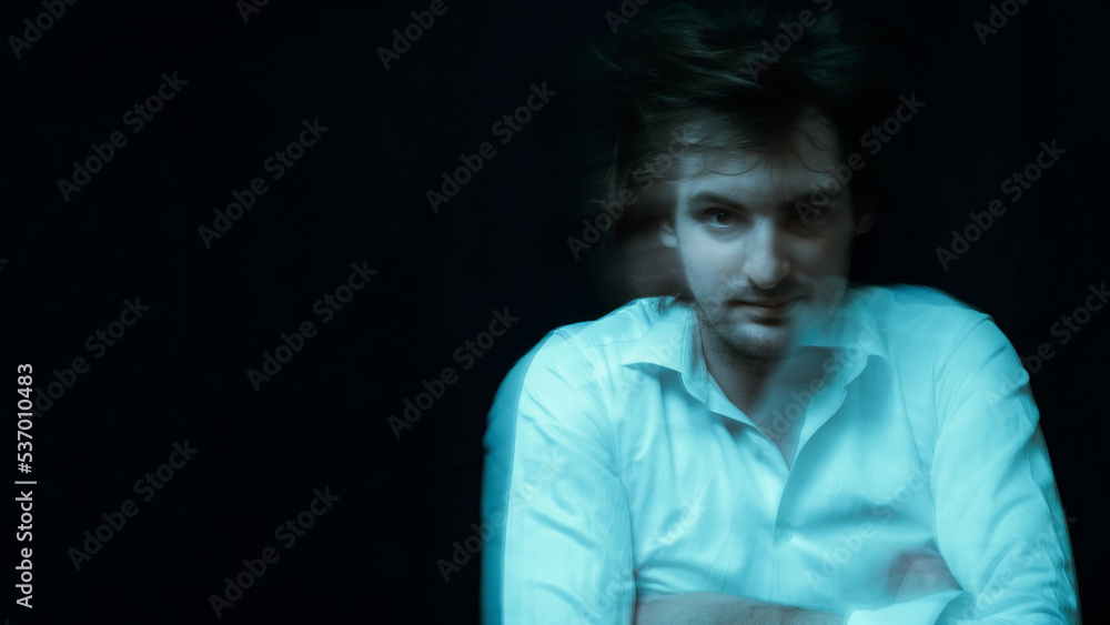Fototapeta premium schizophrenic portrait of man with mental disorders and mental illnesses in straitjacket on dark background
