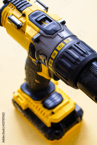 Detail of yellow battery powered drill on color background