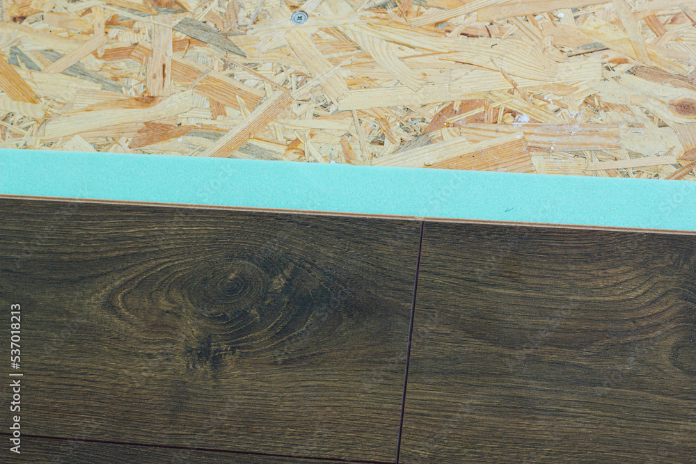 Laminate. Laying brown glossy laminate on the floor of the house