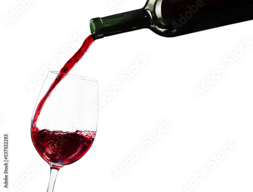 Pouring red wine in a glass isolated on white background