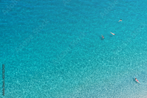 Tropea beach along the Tyrrhenian Sea Coast of Gods (Costa degli Dei). Turquoise color, crystal clear water with swimming relaxed people. Tropea seaside resort city of Calabria, southern Italy.