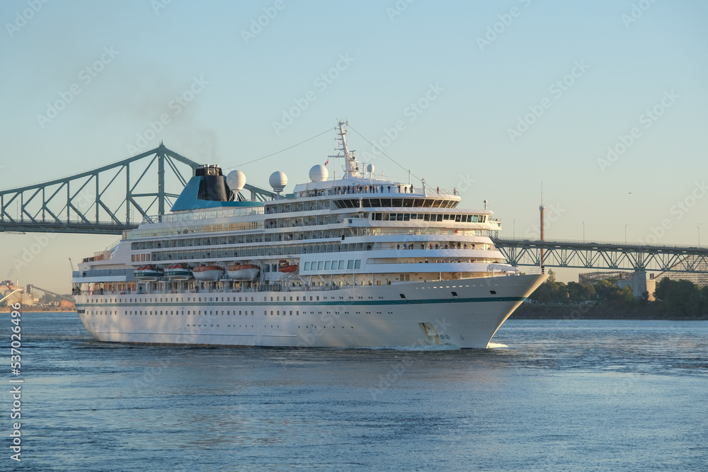 Phoenix cruiseship or cruise ship liner Amera arrival to port Montreal, Canada on sunny day on St. Lawrence River for Indian summer East Coast cruising with downtown skyline, bridge clock tower