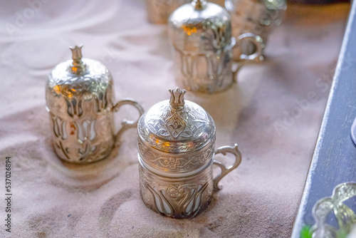 Copper cups with Turkish coffee cooked in hot sand.