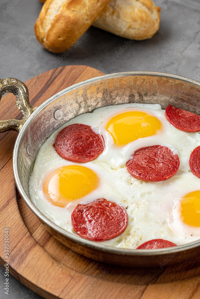 fried eggs with turkish sausage with bread and tea on dark stone table fried eggs with turkish sausage with bread and tea on dark stone table