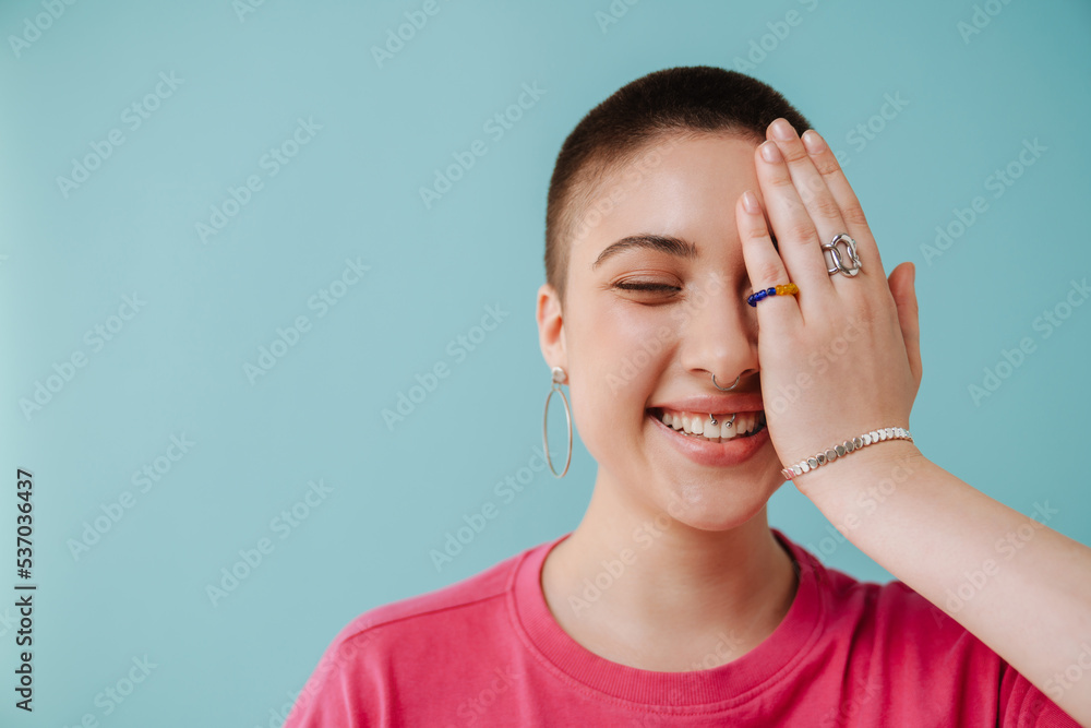 Young european woman with short hair smiling and covering her eye Young european woman with short hair smiling and covering her eye