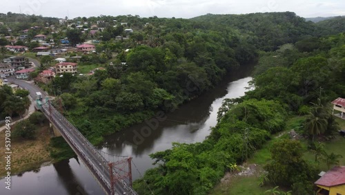 Aerial drone view of an old colonial bridge above a tropical jungle river in the city of San Ignacio, Belize.