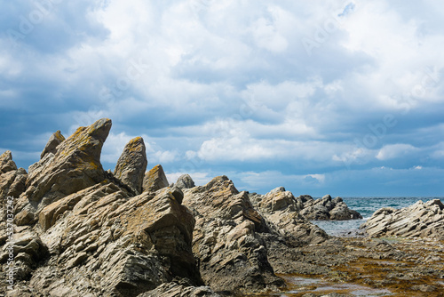 basalt rocks on the sea coast, Cape Stolbchaty on Kunashir Island photo