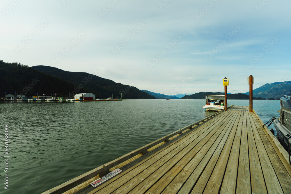 Wooden dock on Harrison Lake, Harrison Hot Springs, late summer, with mountains visible on far horizon.