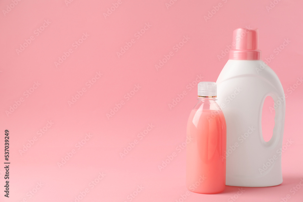 Bottles of laundry detergents on pink background. Space for text Bottles of laundry detergents on pink background. Space for text