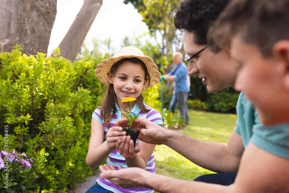 Caucasian family spending time together in the garden, planting Caucasian family spending time together in the garden, planting