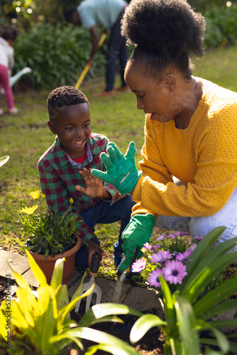 Vertical picture of african american mother and son spending time together in the garden
