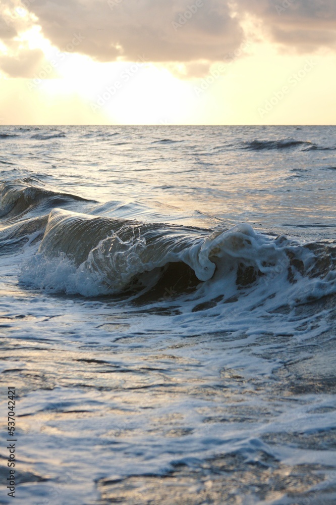 Obraz premium Vertical of ocean waves in Galveston, Texas during sunset