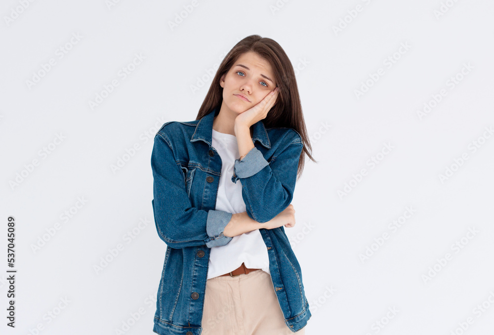 Image of sad casual girl, woman sulking and frowning disappointed, standing upset and distressed against white background Image of sad casual girl, woman sulking and frowning disappointed, standing upset and distressed against white background