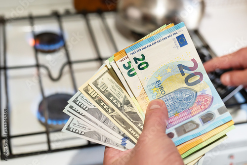 Payment of utilities. Euro and dollar bills lie near a burning gas burner. The concept of increasing the cost of natural gas supply and payment. Energy crisis. High cost, the price of gas.