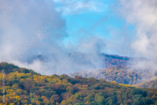 Steam over forested hills in autumn