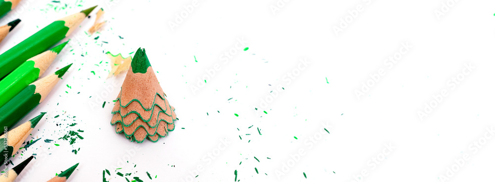 Colored pencils and creative Christmas tree made of shavings from a