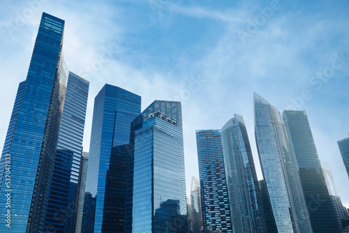 low angle view of singapore city buildings against blue sky 