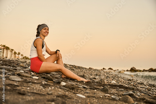 young smiling woman enjoying the beach at the sunset