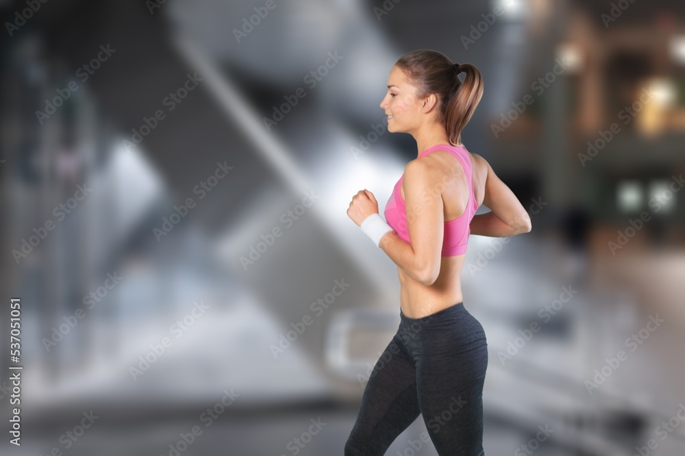 Beautiful young sporty fitness woman posing on street