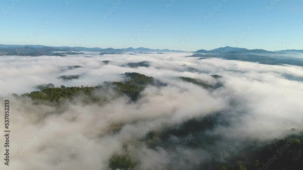Aerial view of mountain road and the greenhouse with fog clouds sun rise on mountain in fog in area of Dalat, Vietnam. Below is the beautiful green pine forest and fog in nature. Aerial view of mountain road and the greenhouse with fog clouds sun rise on mountain in fog in area of Dalat, Vietnam. Below is the beautiful green pine forest and fog in nature.