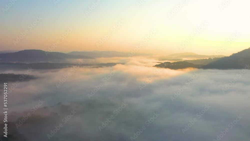 Aerial view of mountain road and the greenhouse with fog clouds sun rise on mountain in fog in area of Dalat, Vietnam. Below is the beautiful green pine forest and fog in nature. Aerial view of mountain road and the greenhouse with fog clouds sun rise on mountain in fog in area of Dalat, Vietnam. Below is the beautiful green pine forest and fog in nature.