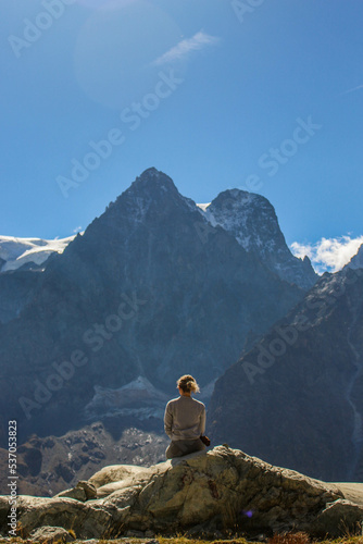 Femme assise devant vue panoramique en montagne