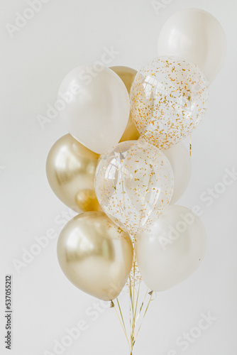 White, gold and transparent glitter balloons. White background.