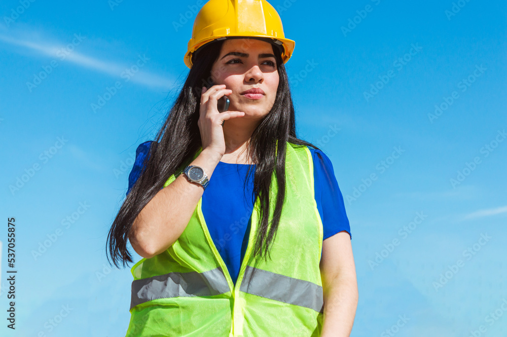 portrait of young engineer woman wearing safety helmet outdoors angry talking on the phone portrait of young engineer woman wearing safety helmet outdoors angry talking on the phone
