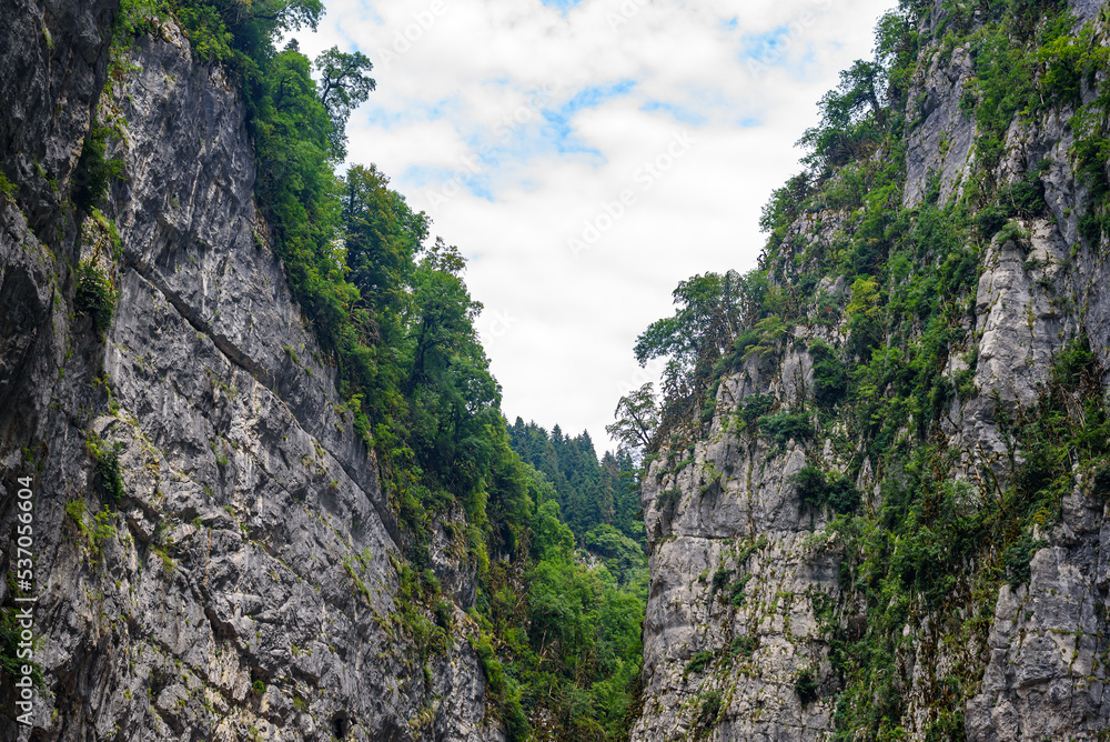 Highland deep bare canyon with green bushes against clouds on blue sky. Green hills with rare trees on mountain resort attracting attention Highland deep bare canyon with green bushes against clouds on blue sky. Green hills with rare trees on mountain resort attracting attention