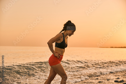 young smiling woman enjoying the beach at the sunset