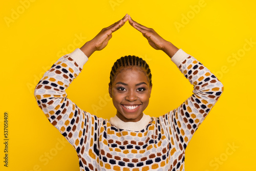 Photo of funky attractive model stylish pullover outfit hold arms over head imagine house roof isolated on yellow color background © deagreez