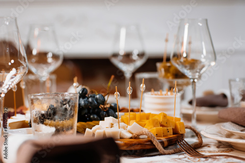 Happy Thanksgiving background, wooden table with glasses and grapes and sliced cheese photo