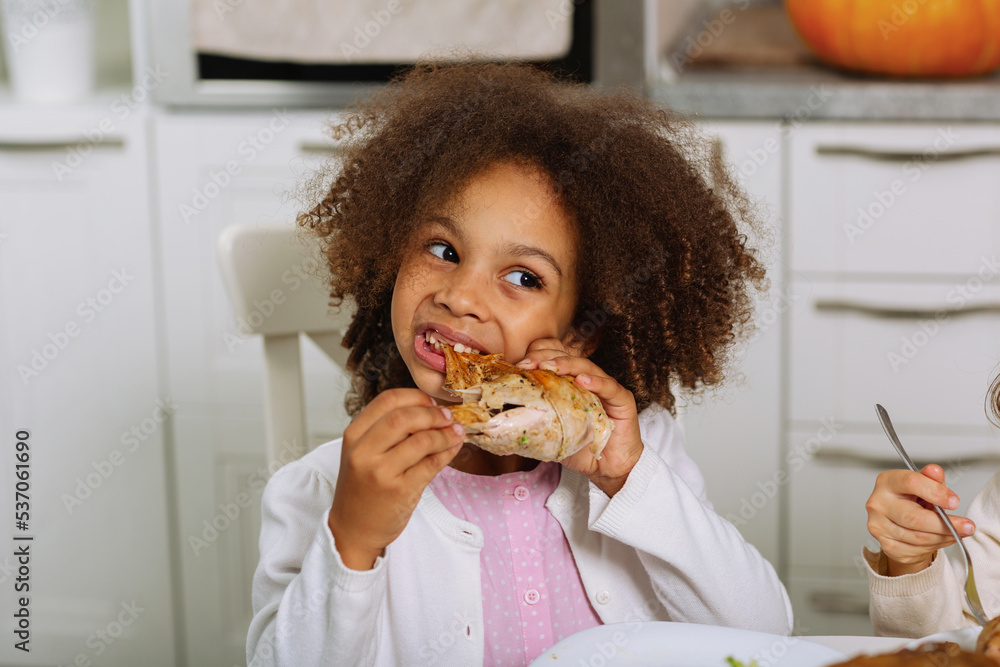 An African-American girl is going to bite off a stuffed turkey on Thanksgiving An African-American girl is going to bite off a stuffed turkey on Thanksgiving