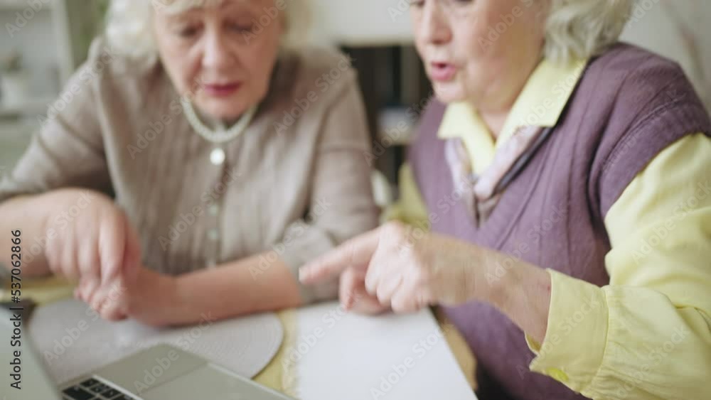 Two women in their 60s learning how to use laptop, problems with technology Two women in their 60s learning how to use laptop, problems with technology