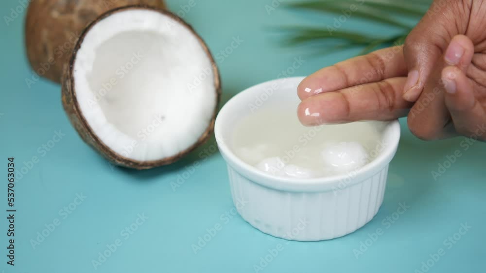hand pick coconut oil from a container hand pick coconut oil from a container