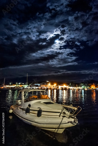 view of Porto Rafti by night under dramatic sky and moon .Greece. photo