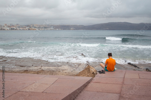 Hombre meditando solo frente al mar.