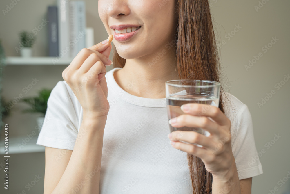 close up person pouring multivitamin capsules to her hands close up person pouring multivitamin capsules to her hands
