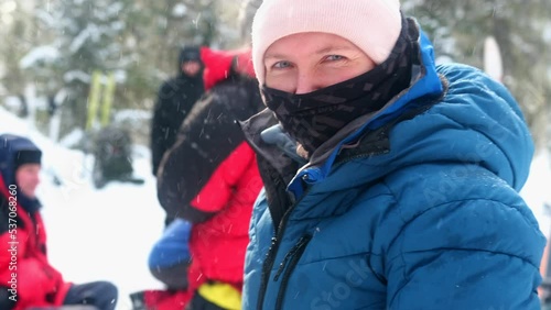 A girl looks slyly during a winter hike. The girl turns and tries to consider what distracted and alerted her. photo