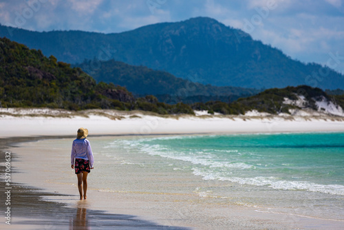 beautiful girl in dress and shirt and hat walks on paradise beach with white sand and turquoise water  walk on whitehaven beach on whitsunday island in queensland  paradise beaches of australia  sunny © Jakub