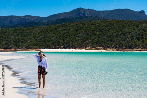 a beautiful girl in a dress, shirt and hat enjoys a walk on the white dunes at whitehaven beach  paradise beach with white sand and turquoise waters  whistundays island holiday, queensland, australia  © Jakub