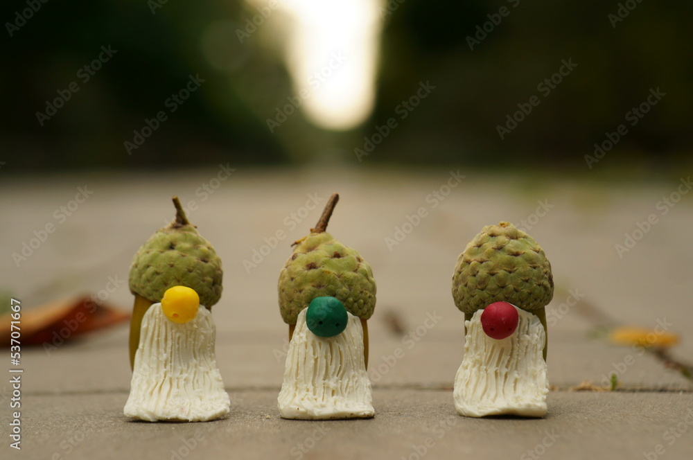 Homemade figures of dwarfs made of plasticine and acorns close-up. The symbol of autumn.