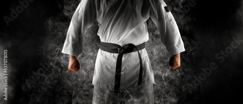 Karate master in white kimono with black belt photo