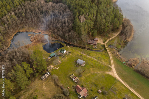 Drone view of cabins in the woods near a lake